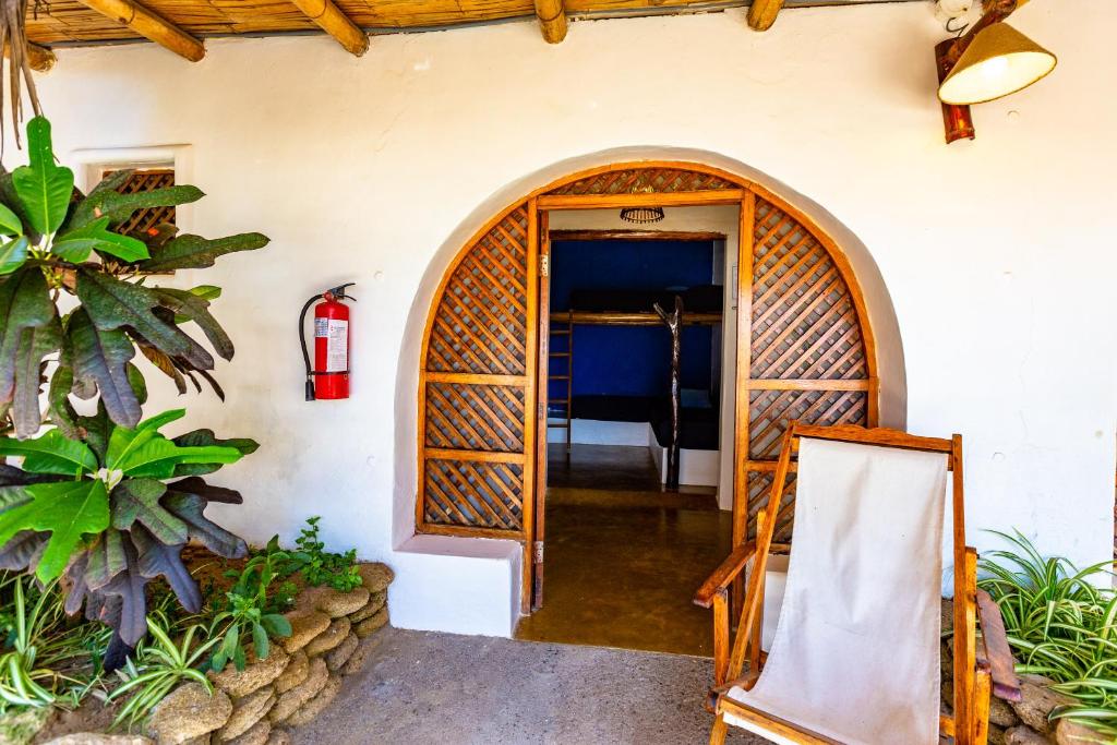 an entrance to a house with a wooden door at Del Wawa in Máncora