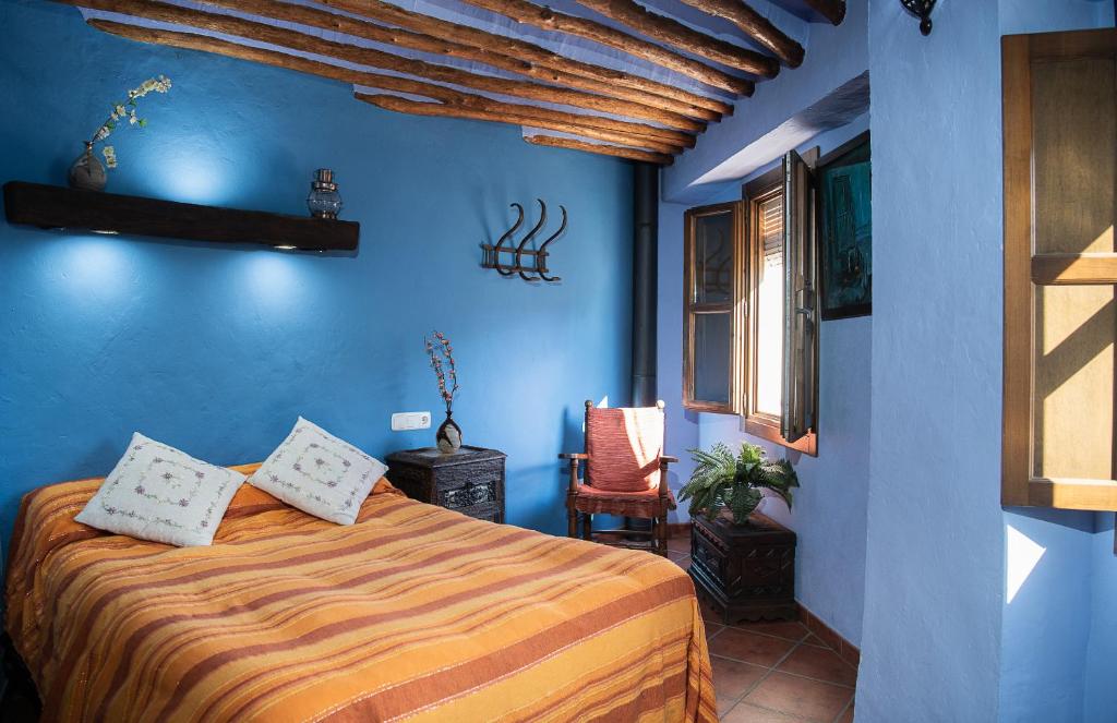 1 dormitorio con 1 cama en una habitación azul en Casilla Dalea en Carcabuey, descubre el interior de Andalucia, en Carcabuey