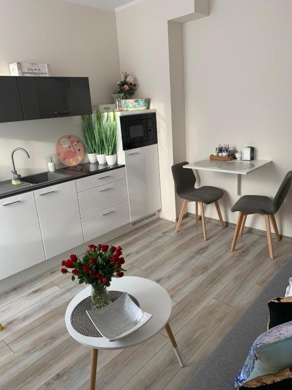 eine Küche und ein Wohnzimmer mit einem Tisch und Stühlen in der Unterkunft Apartament Walczaka 25 MIEJSCE PARKINGOWE in Gorzów Wielkopolski