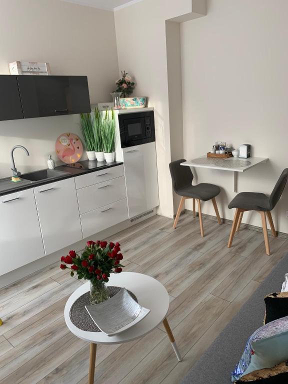 Una cocina y una sala de estar con mesa y sillas. en Apartament Walczaka 25 MIEJSCE PARKINGOWE, en Gorzów Wielkopolski