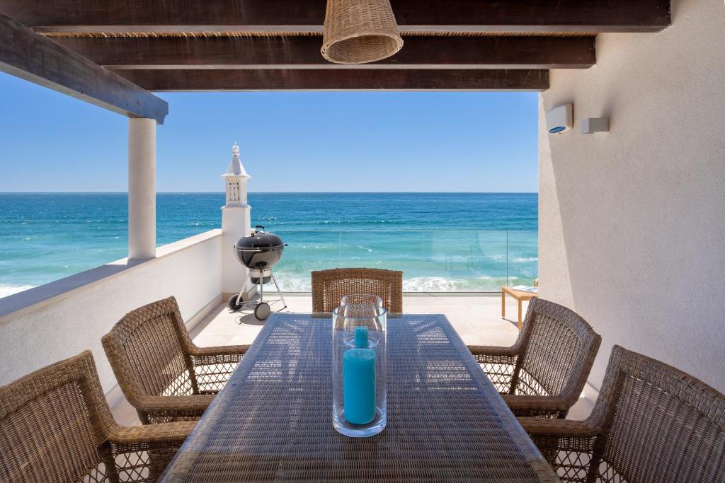Residence Sol e Mar في ساليما: طاولة عليها زجاجة زرقاء على الشاطئ