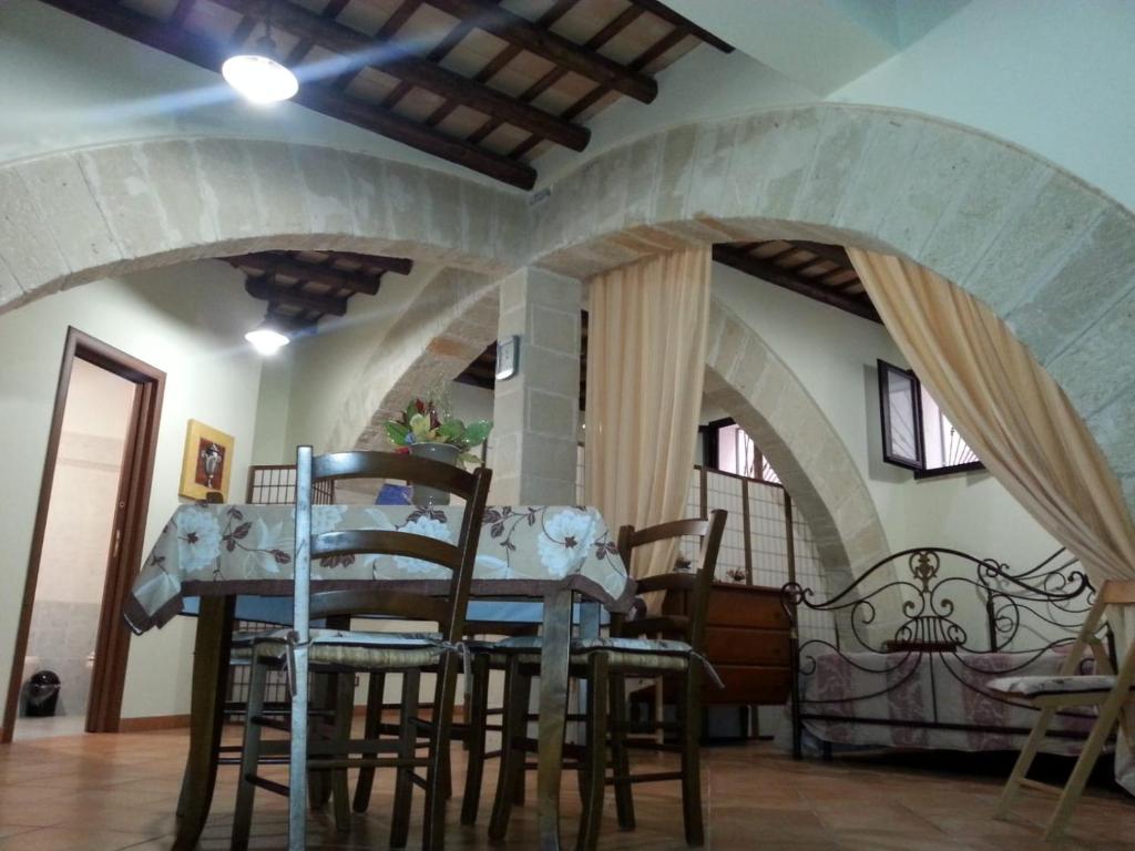 een eetkamer met gewelfde plafonds en een tafel en stoelen bij TRAPANI HOME in Trapani