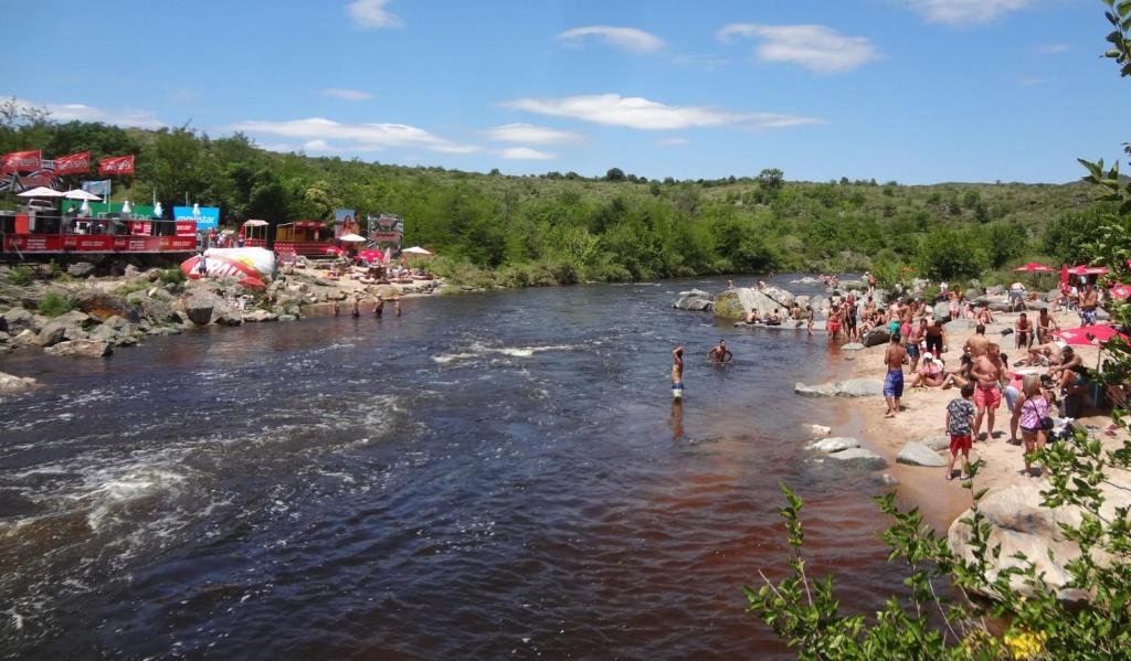 a crowd of people standing on the shore of a river at Casa en Mayú Sumaj a metros del Río. in San Antonio de Arredondo