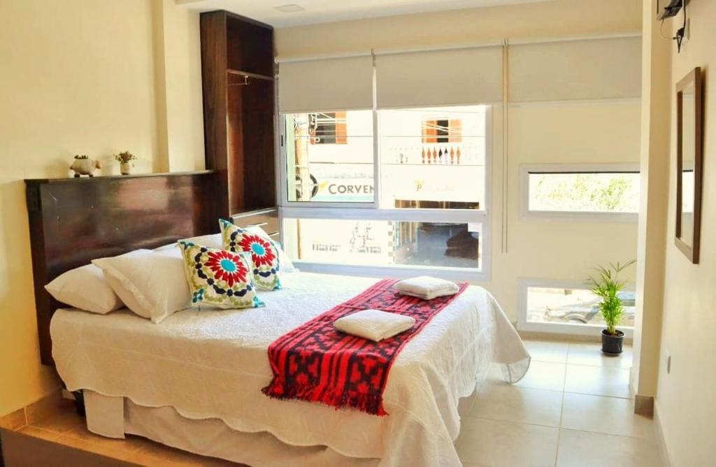 Un dormitorio con una cama con una manta roja. en Apart Hotel Urku Wasi en San Salvador de Jujuy