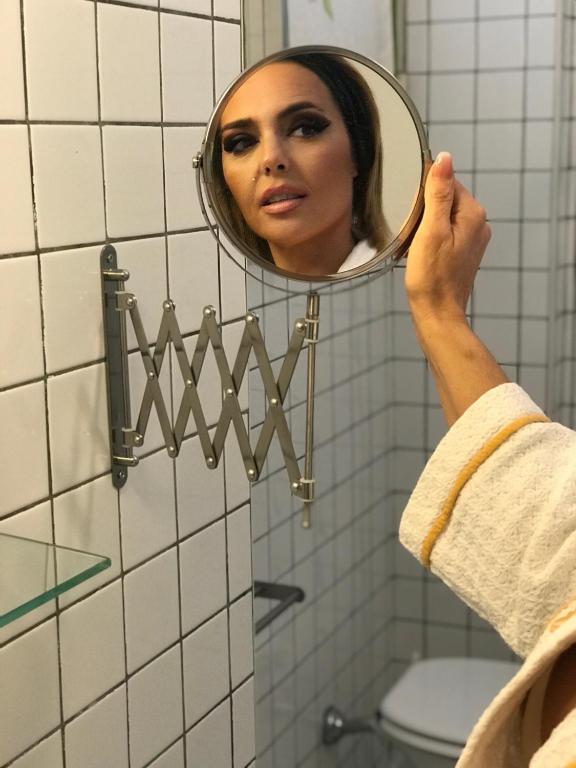 Kobieta patrzy na swoje odbicie w lustrze. w obiekcie B&B La Corte w mieście SantʼAntimo
