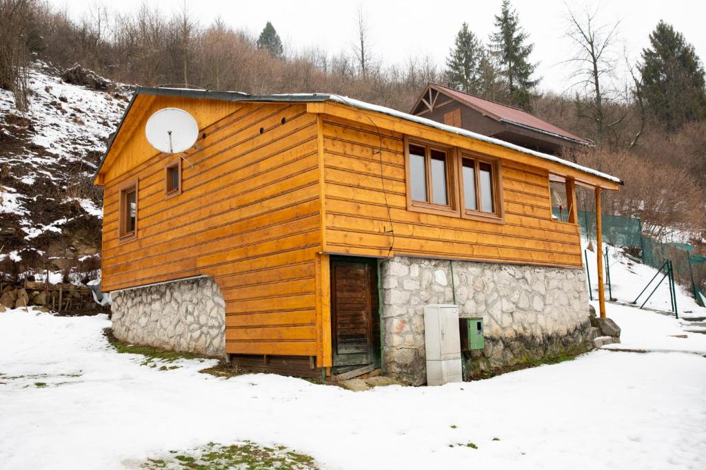 een klein houten huis in de sneeuw bij Chata Pohoda pri Jánošíku in Terchová
