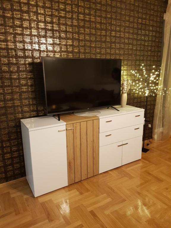 a flat screen tv sitting on top of a white dresser at Sunrise apartman in Bijeljina