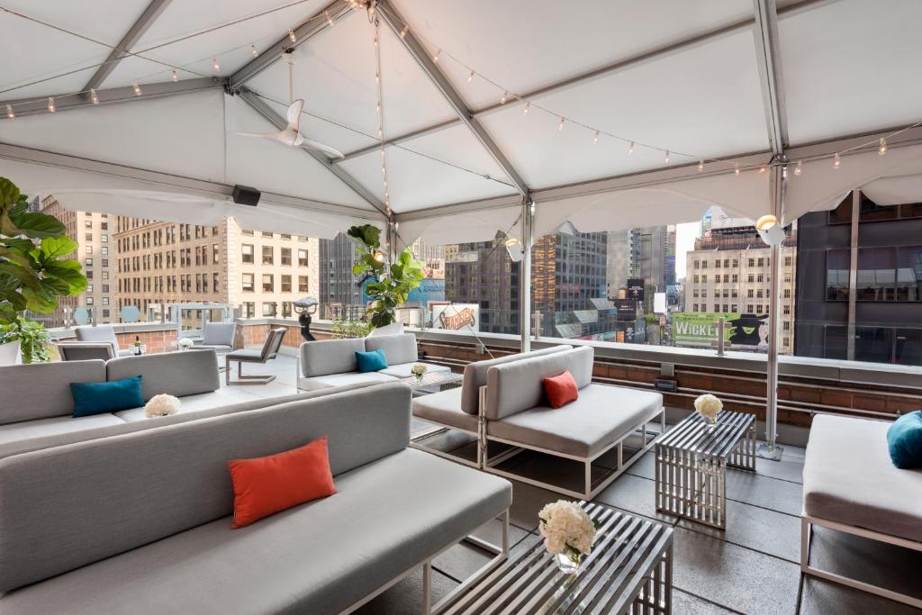 a rooftop patio with couches and a view of a city at M Social Hotel Times Square New York in New York