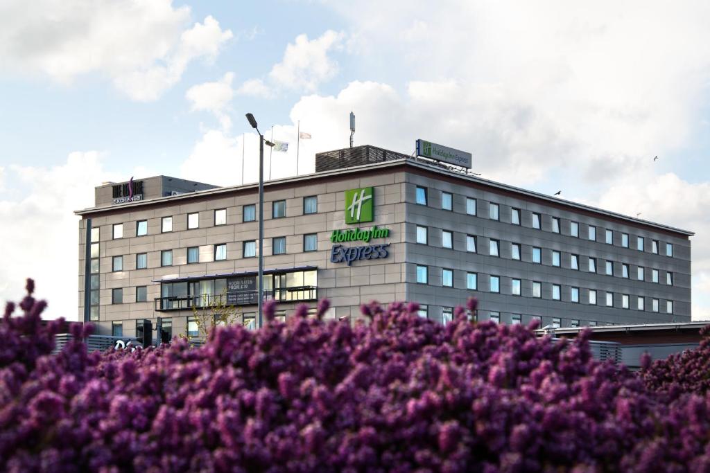 un edificio con flores púrpuras delante de él en Holiday Inn Express Bradford City Centre, an IHG Hotel, en Bradford