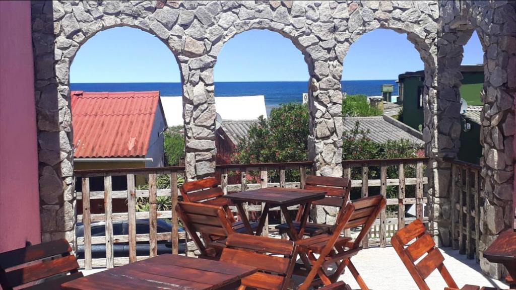 una mesa y sillas en un balcón con vistas al océano en Belarmina posada del mar., en Aguas Dulces