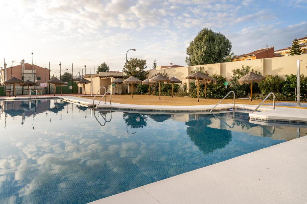 ein großer Pool mit Sonnenschirmen in einem Resort in der Unterkunft Casa Loli in Torre del Mar