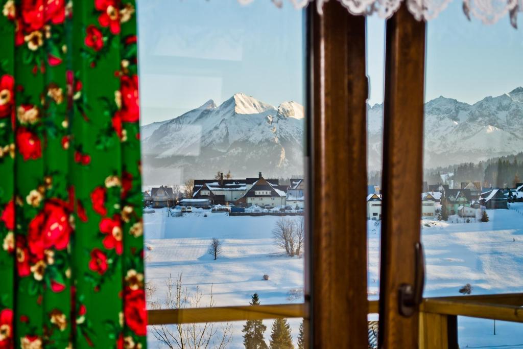 a view of a snowy mountain from a window at Pokoje "u Kuruców" in Bukowina Tatrzańska