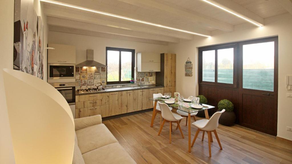 a kitchen and living room with a table and chairs at casa tre noci in Lascari