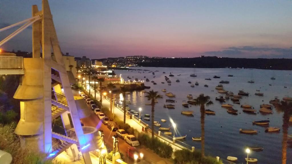 - une vue sur un port avec des bateaux dans l'eau la nuit dans l'établissement Sea Side Porto Paolo, à San Pawl il-Baħar