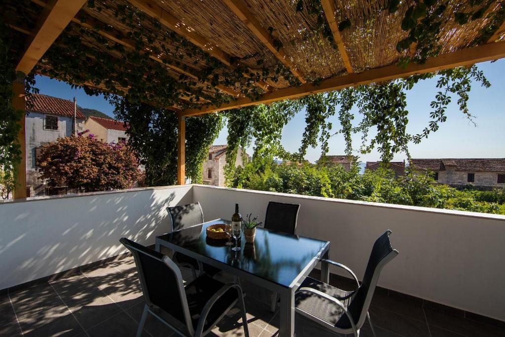 a patio with a table and chairs on a balcony at Guesthouse Ksenija in Komiža