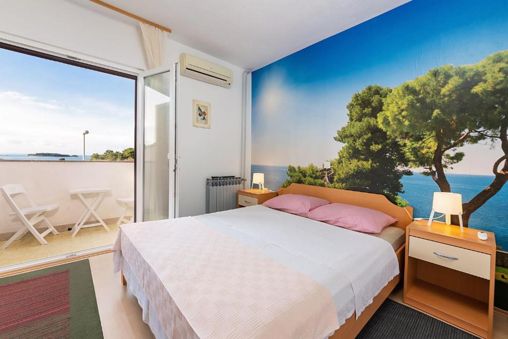 a bedroom with a bed and a view of the ocean at Apartments Pilicari in Rovinj