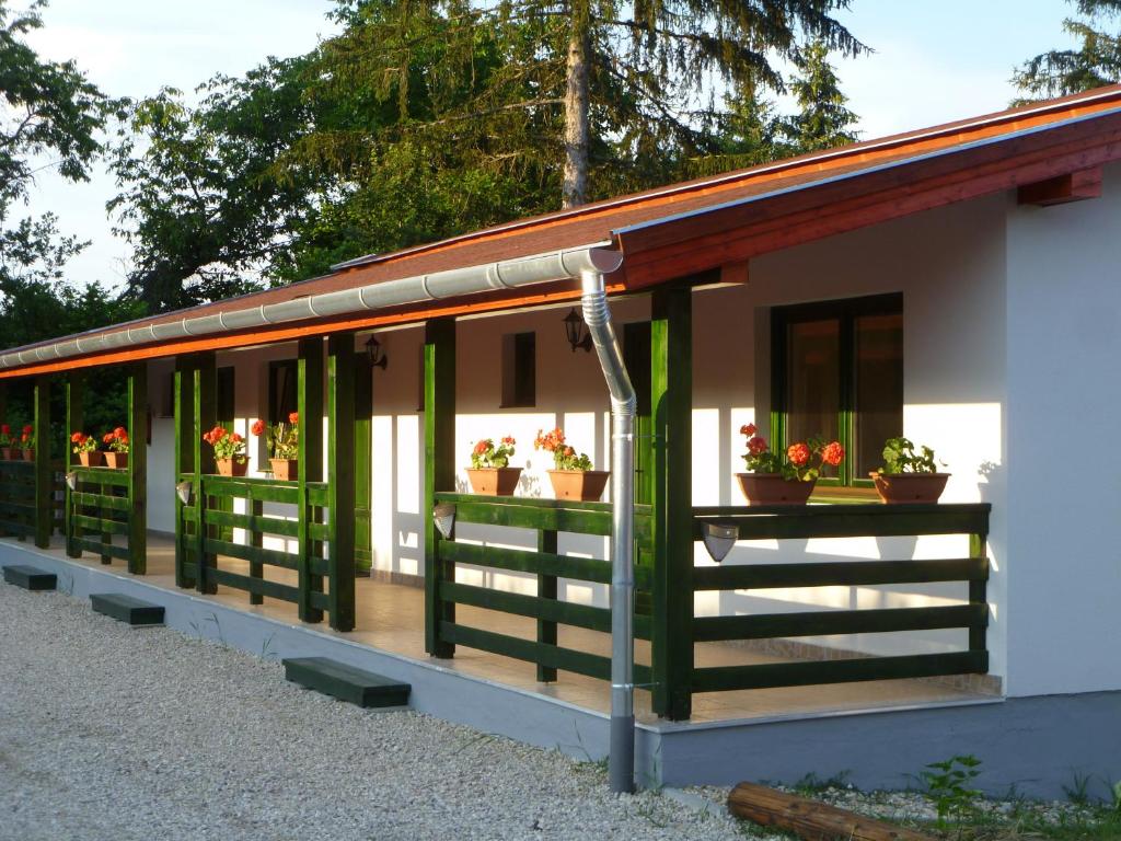 a building with potted plants on the windows at Kisrejtek Apartmanház in Lispeszentadorján