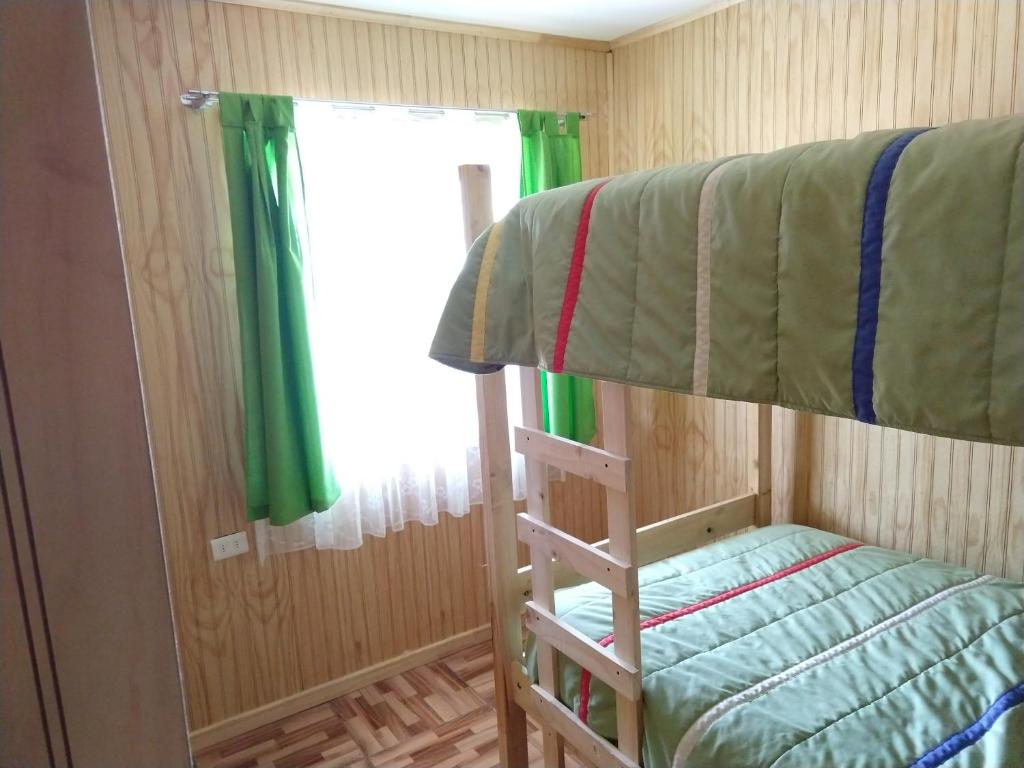 a bedroom with a bunk bed and a window at Cabaña entre rios in Villarrica