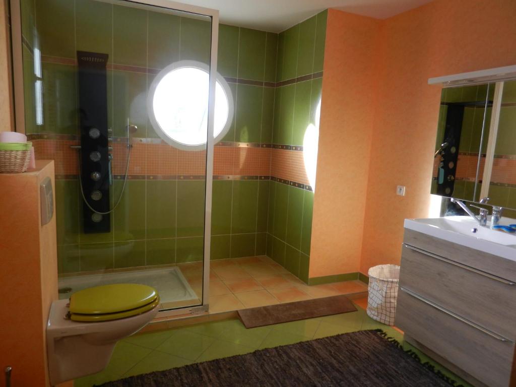 a bathroom with a shower with a toilet and a sink at VILLA THEDIEBERT in Barneville-Carteret
