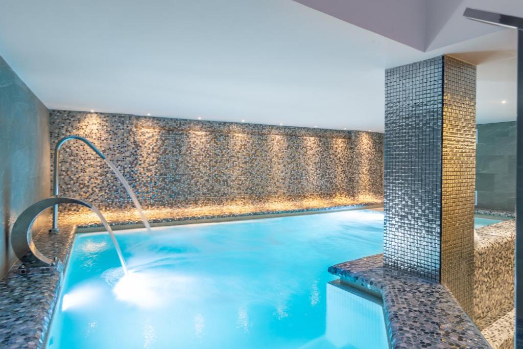 een zwembad met een waterpartij in een gebouw bij Spa del Palacete in Málaga