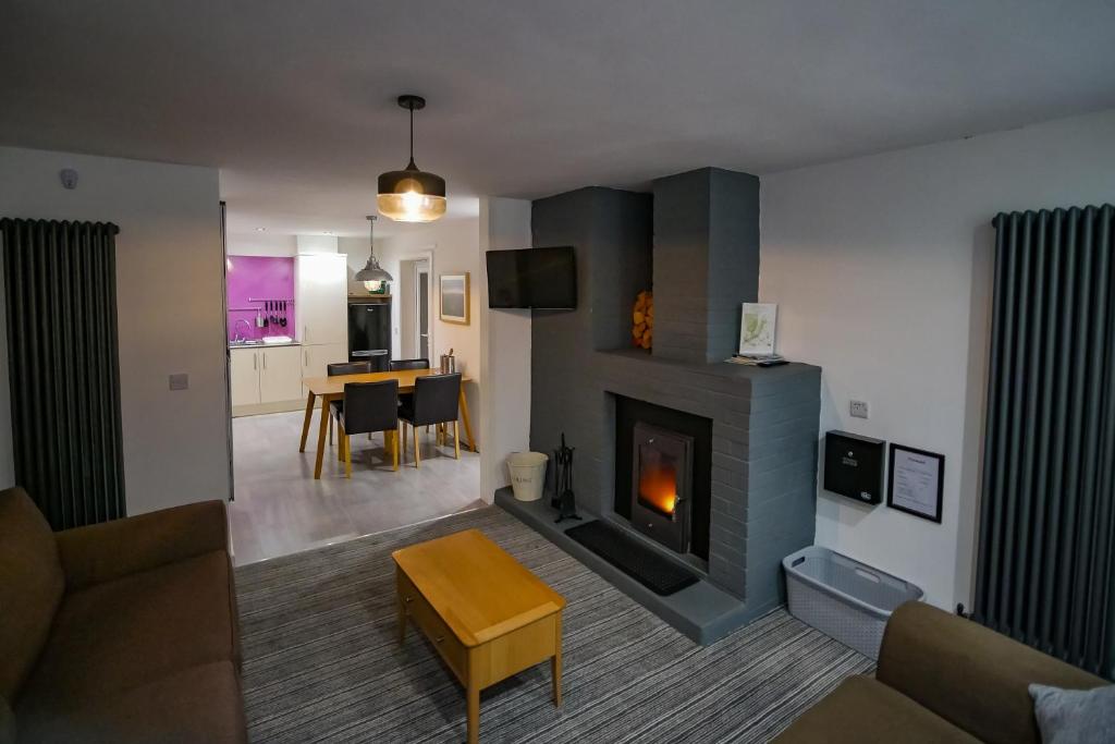 a living room with a fireplace and a dining room at Canyon Cottage in Pont-Nedd-Fechan