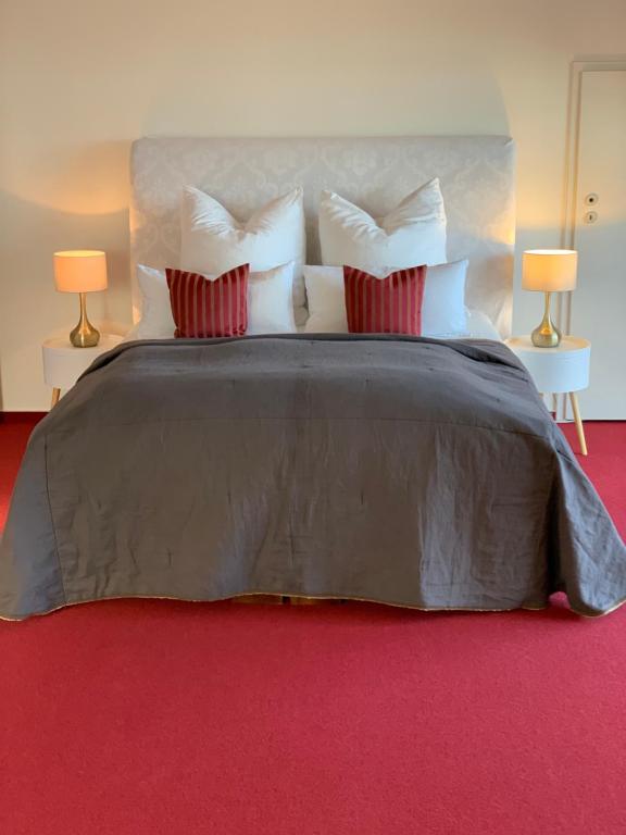 a large bed with white pillows on a red carpet at Familien-Suite in Villa in Hildesheim