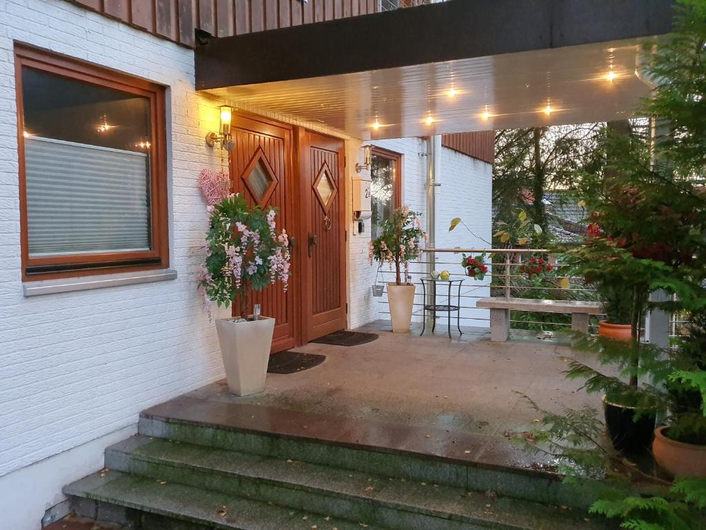 a front door of a house with potted plants at Apartment bei Hamburg bis 10 Personen mit Terasse und Gartennutzung. in Buchholz in der Nordheide