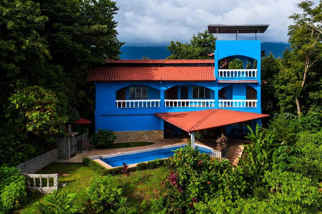 a blue house with a swimming pool in front of it at El Paraiso Azul in Ojochal