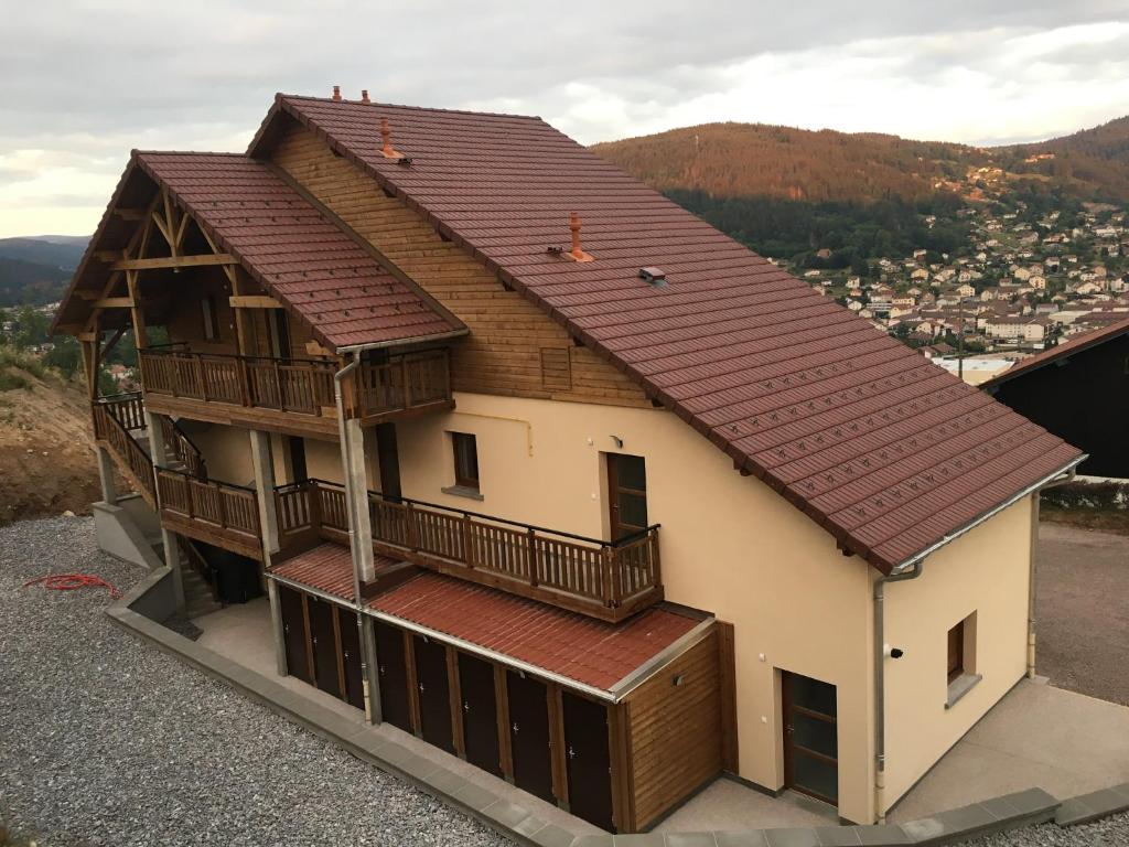 a house with a roof with a balcony at Les balcons de la haie griselle in Gérardmer