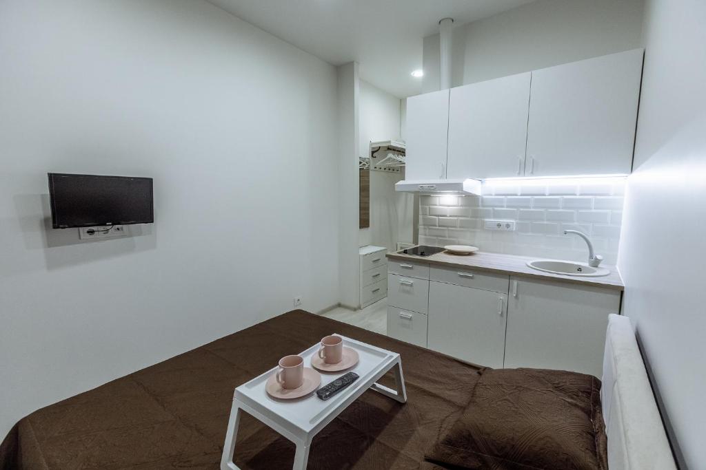 uma pequena cozinha branca com uma mesa num quarto em Švitrigailos 7 em Vilnius