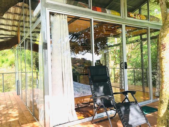 a black chair sitting on the porch of a house at Cabaña treehouse Mountain View in San Isidro