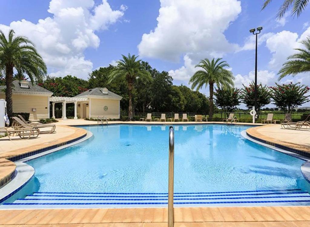 uma grande piscina com palmeiras num resort em Heritage Haven em Kissimmee