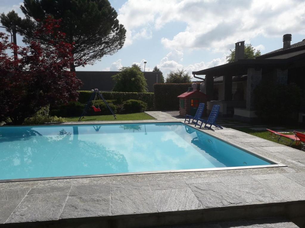 a swimming pool in a yard with two chairs at RESIDENZA BERETTA Como Lake B in Orsenigo
