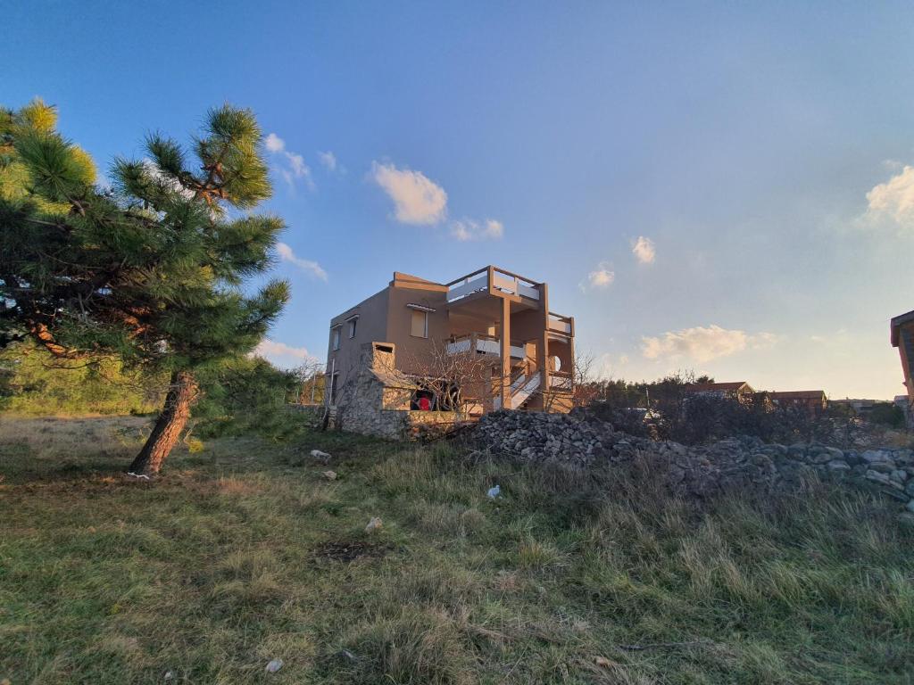 a house sitting on top of a hill in a field at Apartmani Bellevue in Vir