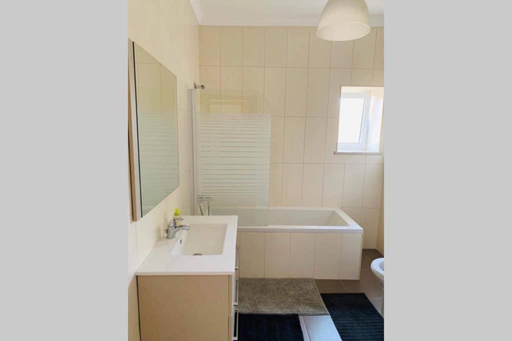 a bathroom with a sink and a bath tub at Beach House (Leirosa) in Figueira da Foz