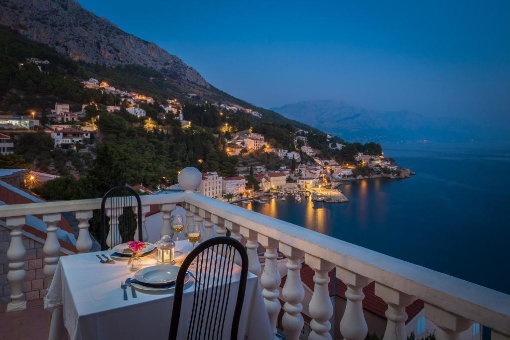 a table on a balcony with a view of the water at Family Beach Rooms in Omiš