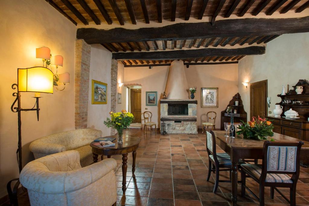 a living room with a table and chairs and a fireplace at Camere Dentro Il Castello in Monteriggioni