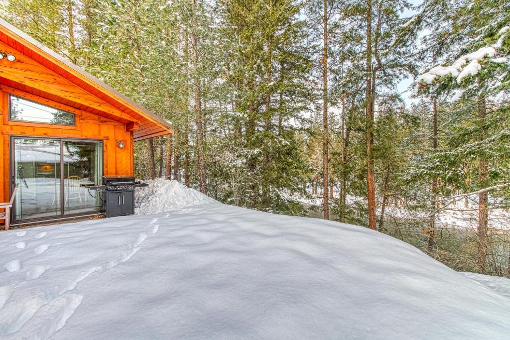 a snow covered driveway to a cabin in the woods at River Song Cabin in Leavenworth
