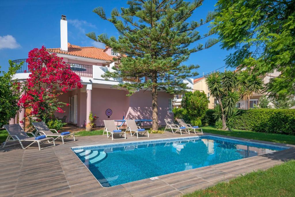 a swimming pool in front of a house at Anna's Brilliant Villa in Ialysos in Ialysos