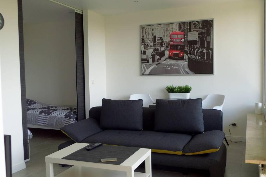 a living room with a couch and a red double decker bus at Modernes Apartment Duisburg in Duisburg