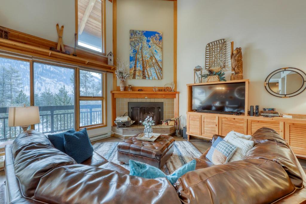 uma sala de estar com um sofá de couro e uma televisão em Pines 2041 em Keystone