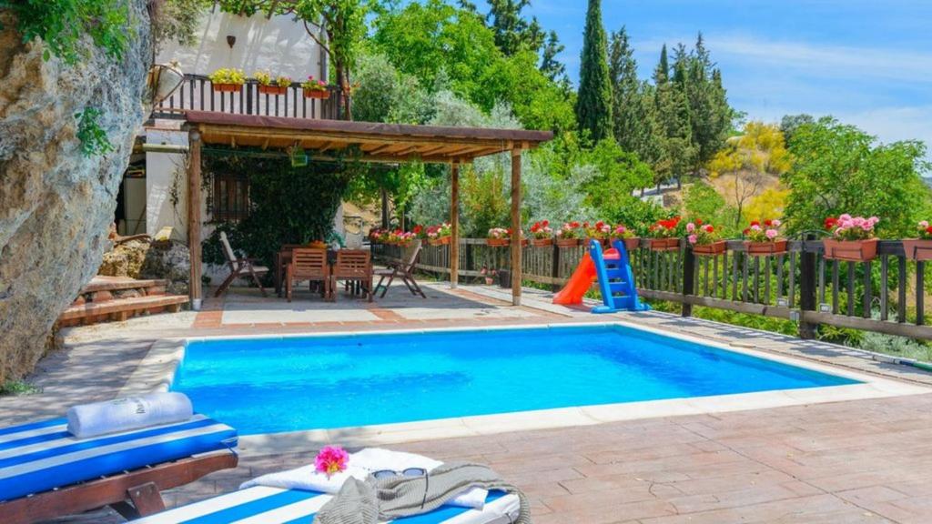 - une piscine avec une terrasse et une maison dans l'établissement El Tajil, à Algarinejo
