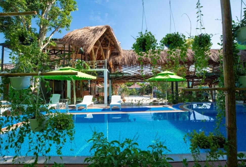 ośrodek z basenem z leżakami i parasolami w obiekcie Bamboo Resort Phu Quoc w Duong Dong