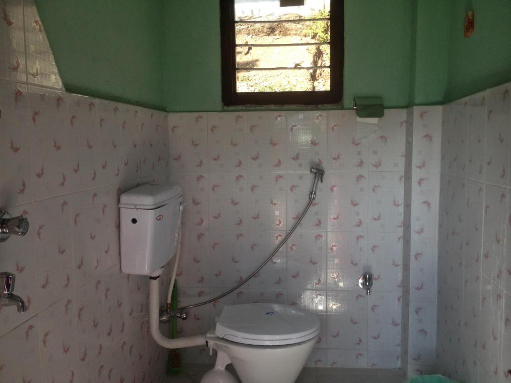 bagno con servizi igienici e finestra di Peace Guest House a Pokhara