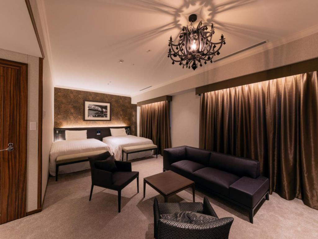 a hotel room with a bed and a couch at LIBER HOTEL Osaka in Osaka