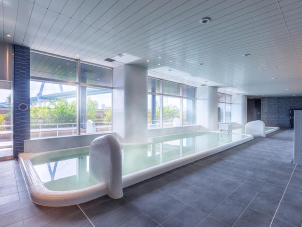 a large room with a glass table and chairs at LIBER HOTEL Osaka in Osaka