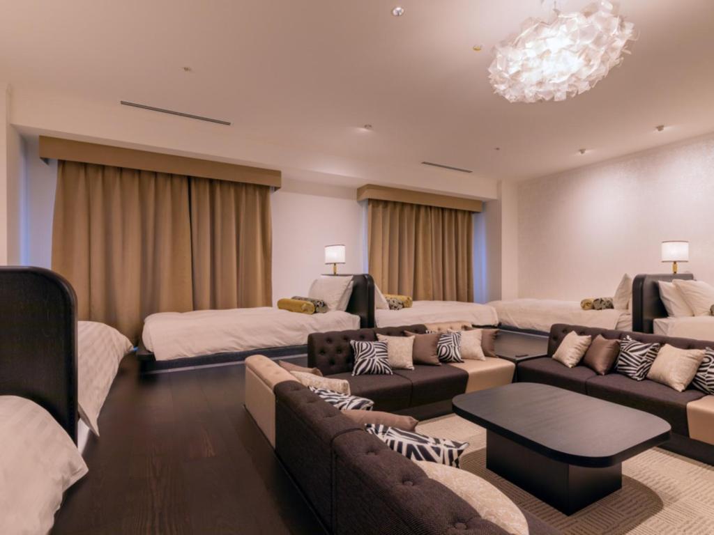 a large living room with couches and a chandelier at LIBER HOTEL Osaka in Osaka