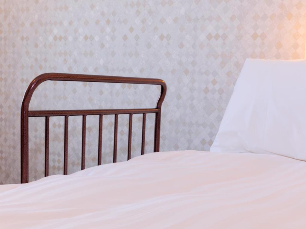 a close up of a bed with a white sheet at LIBER HOTEL Osaka in Osaka