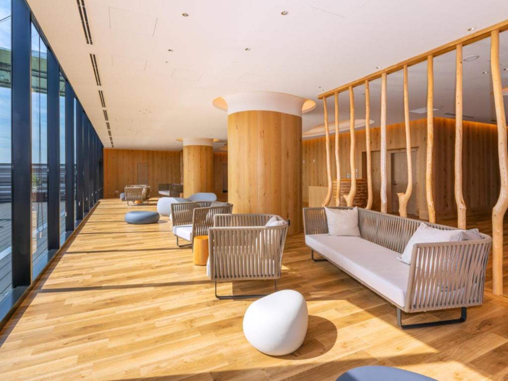a lobby of a building with chairs and tables at LIBER HOTEL Osaka in Osaka