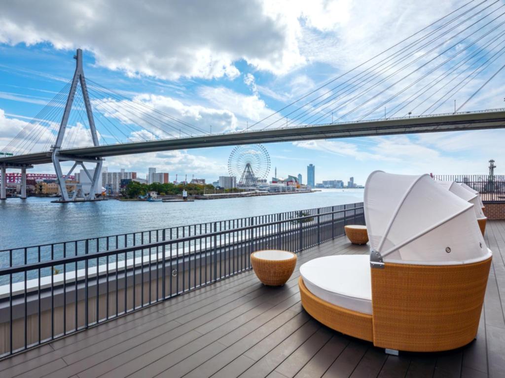 a deck with a view of the river and a bridge at LIBER HOTEL Osaka in Osaka
